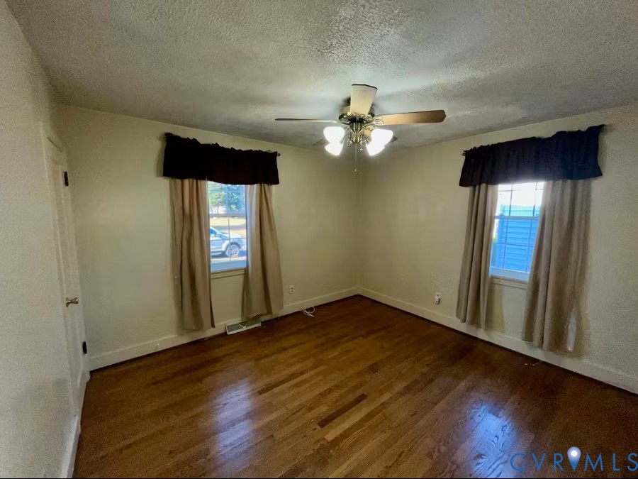 7318 Atlee Road Mechanicsville, VA 23111 - Photo 7 of 19 an empty room with wooden floor chandelier fan and windows