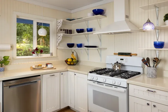 a kitchen with a stove a sink and cabinets