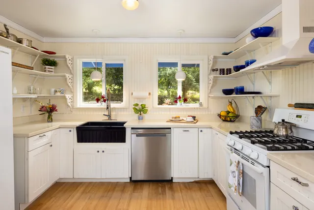 a kitchen with a white cabinets stove and sink