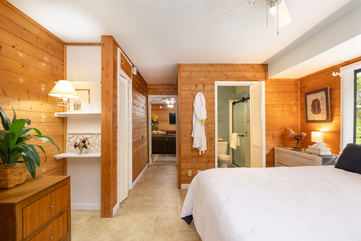 45-1006 Kalehua Road Honokaa, HI 96727 - Photo 10 of 29 a bedroom with a bed a mirror and a potted plant