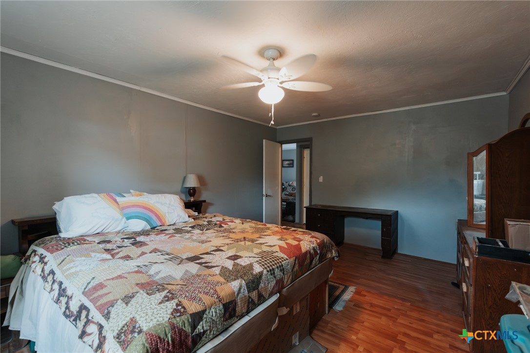 200 Williams Street Cuero, TX 77954 - Photo 11 of 17 a bedroom with a bed and a chandelier