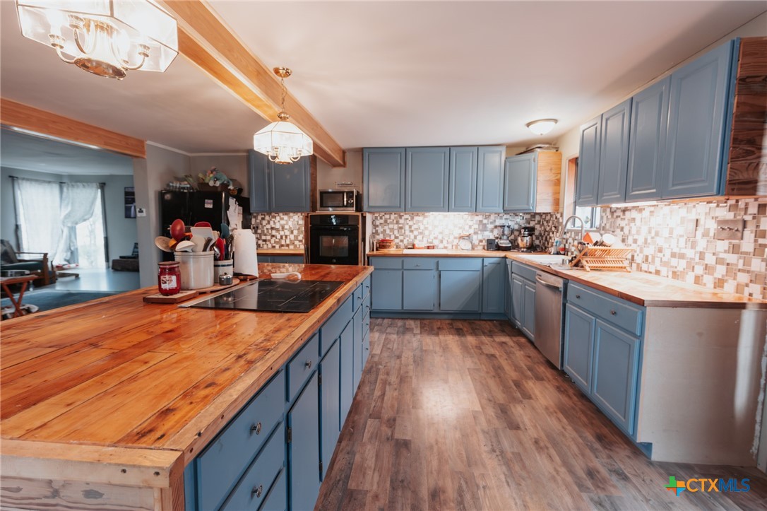 200 Williams Street Cuero, TX 77954 - Photo 4 of 17 a large kitchen with stainless steel appliances kitchen island granite countertop a large counter top space a sink and cabinets