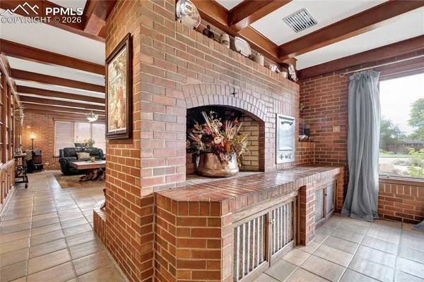 a living room with stainless steel appliances granite countertop furniture a fireplace and a large window