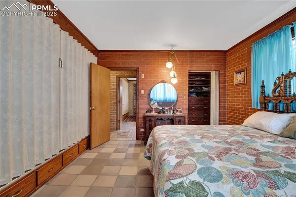 a bedroom with a bed and painting on the wall