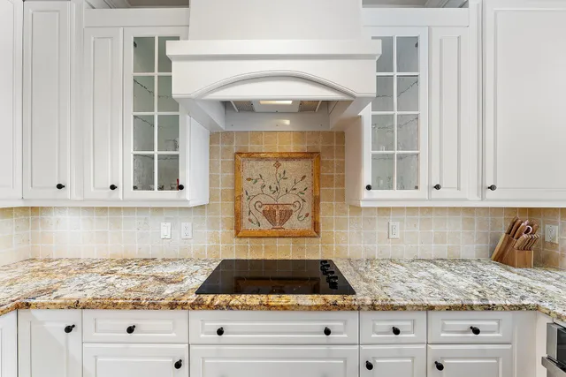 a kitchen island with granite countertop a table and chairs in it