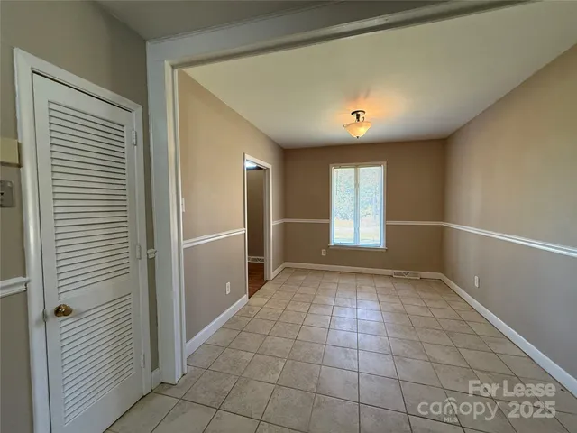 a view of an empty room with window and cabinet
