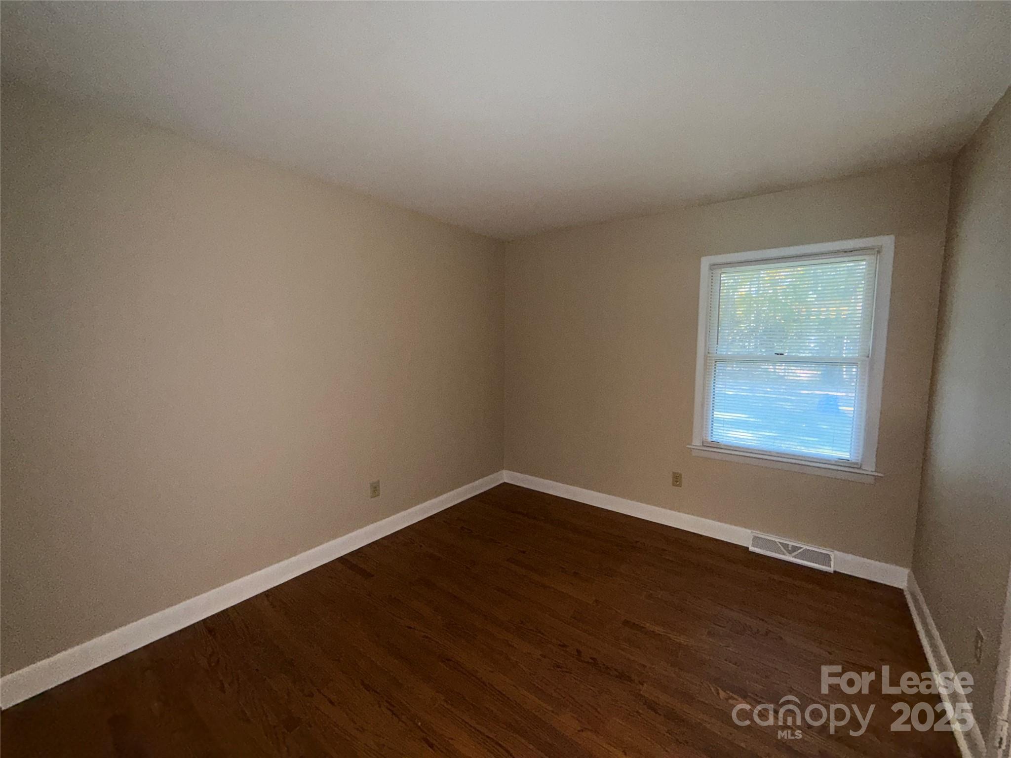 925 Perth Road Troutman, NC 28166 - Photo 17 of 31 an empty room with wooden floor and windows