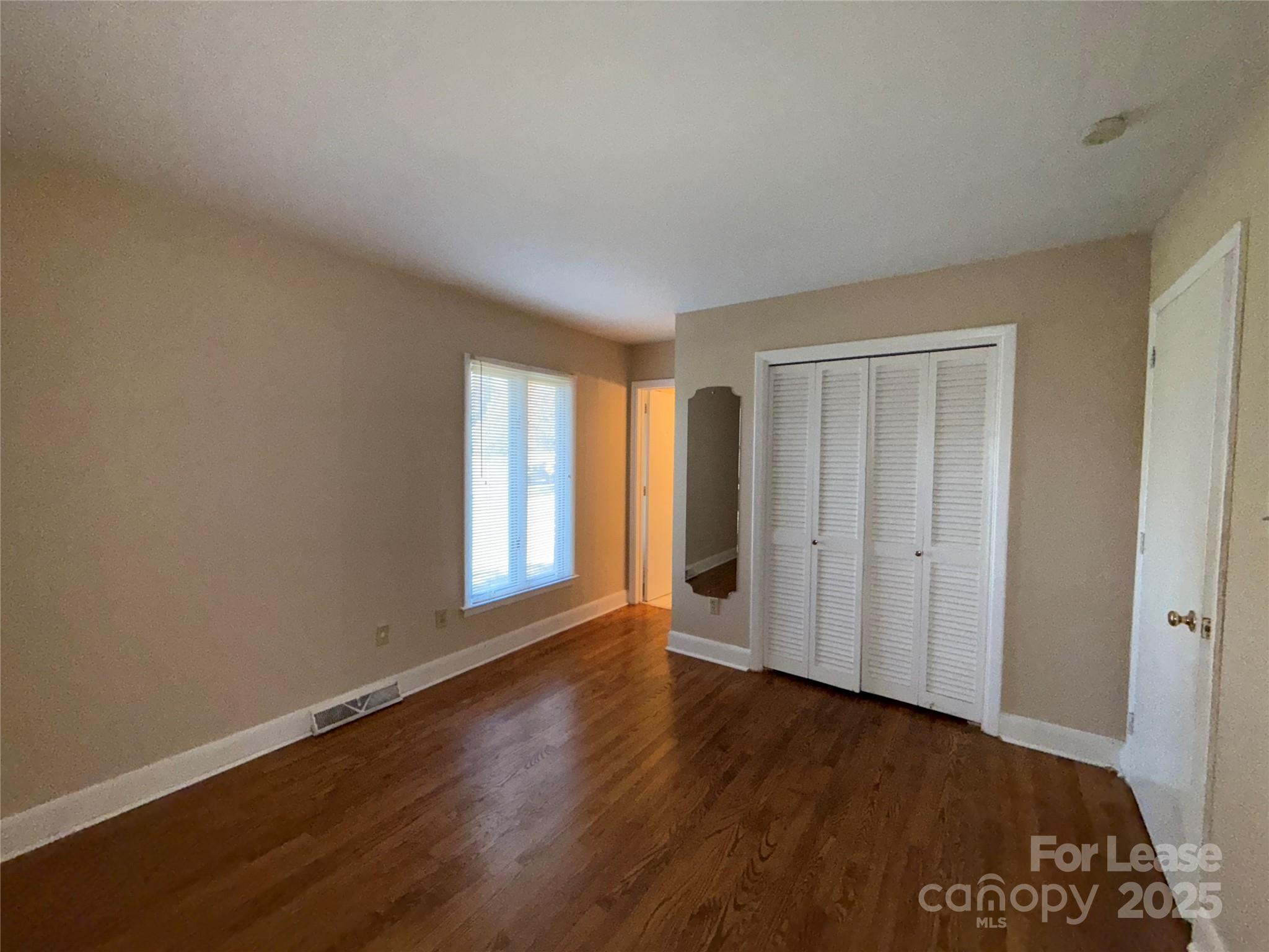 925 Perth Road Troutman, NC 28166 - Photo 21 of 31 a view of an empty room with wooden floor and a window