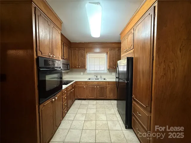 a large kitchen with a stove top oven a refrigerator and dishwasher