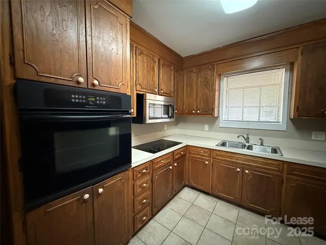 a kitchen with sink a microwave and cabinets