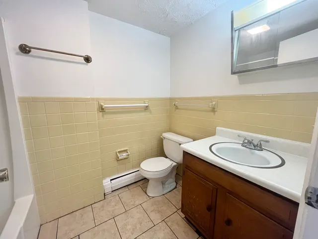 a bathroom with a toilet a sink and mirror