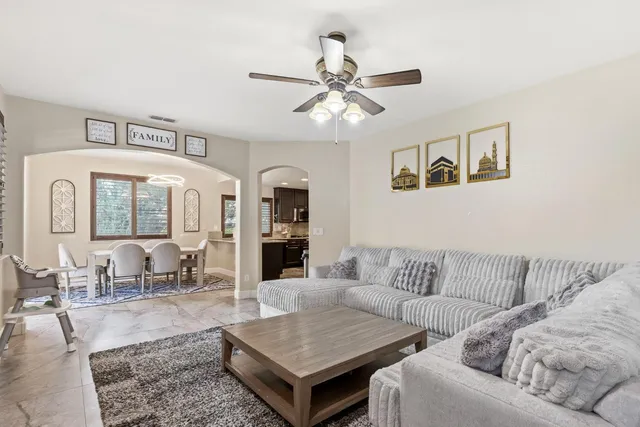 a living room with furniture a fireplace and a chandelier