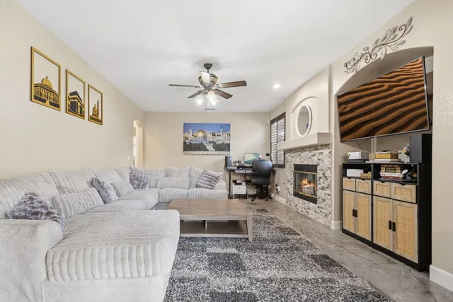 a living room with furniture a fireplace and a large window