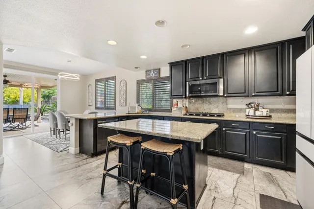 a kitchen with stainless steel appliances granite countertop a sink stove and refrigerator