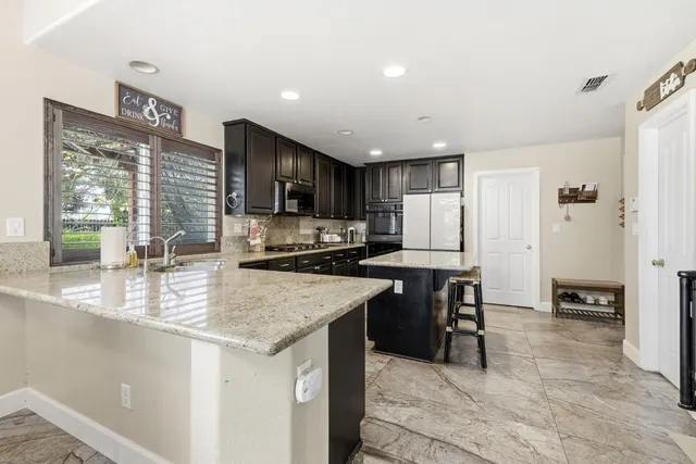 a kitchen with granite countertop stainless steel appliances a refrigerator and counter space