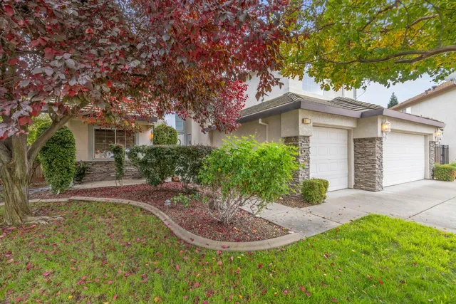 a front view of a house with a yard and potted plants