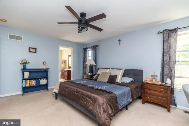 a spacious bedroom with a bed a window and a book shelf