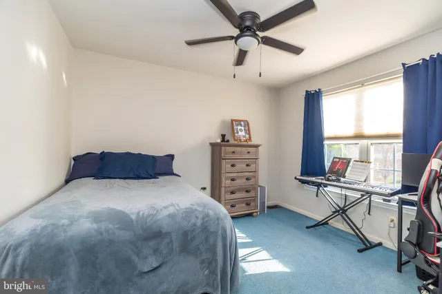 a bedroom with a bed a dresser and a window
