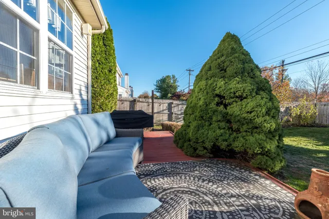 a balcony with lots of white furniture and a yard
