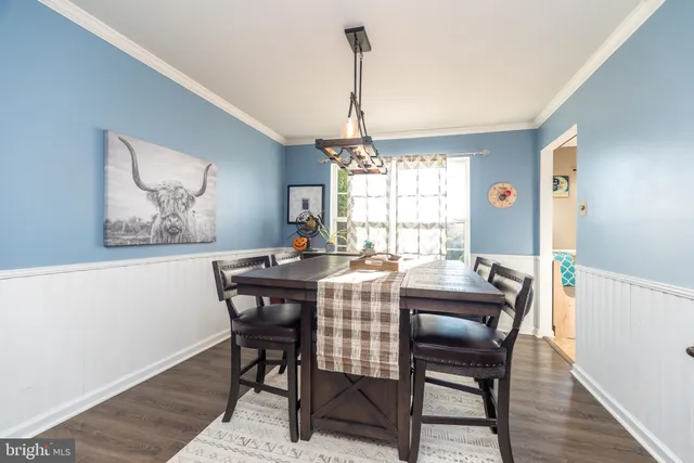 a dining room with furniture a chandelier and wooden floor