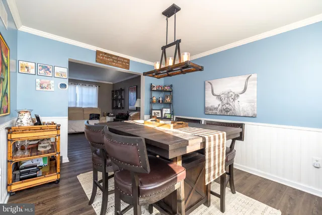 a view of a dining room with furniture a rug and wooden floor