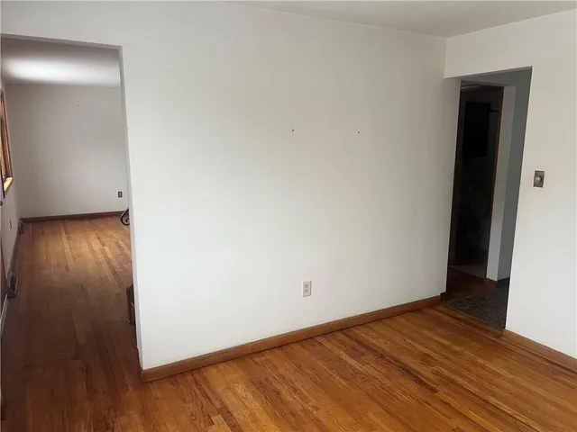 a view of a room with wooden floor and bench