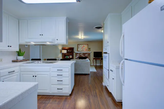 a kitchen with cabinets appliances and a wooden floor