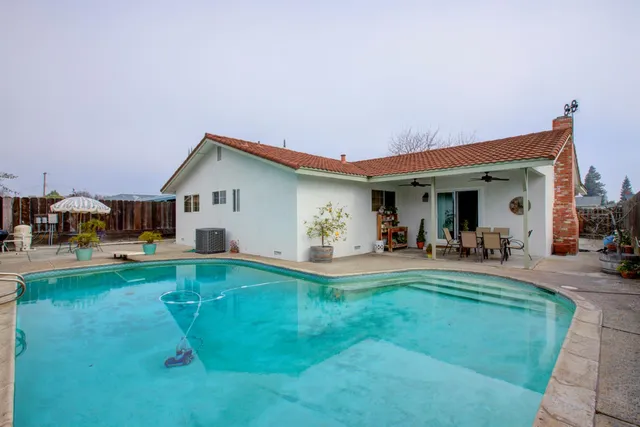 a view of a house with sitting area and swimming pool