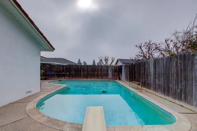 a view of a backyard with swimming pool