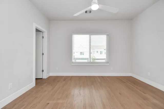 a view of an empty room with wooden floor