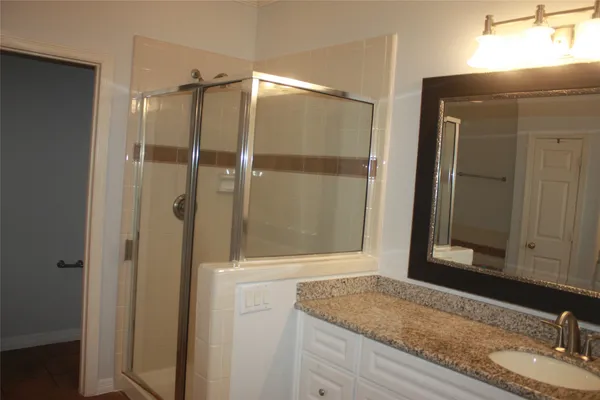 a bathroom with a granite countertop sink and mirror