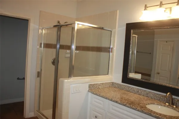 a bathroom with a granite countertop sink and mirror
