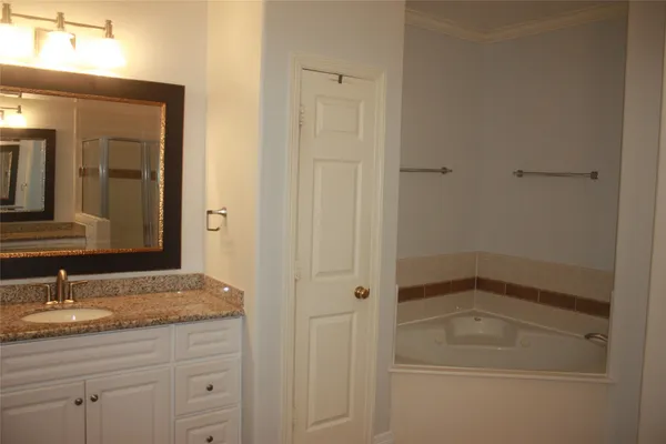 a bathroom with a granite countertop sink a mirror and a shower