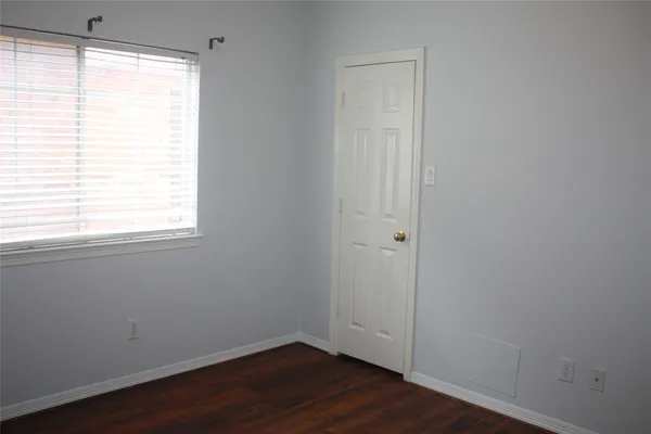 an empty room with wooden floor and a window