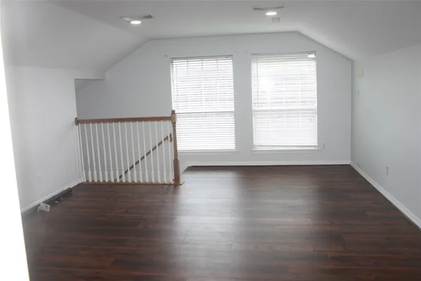 a view of an empty room with wooden floor