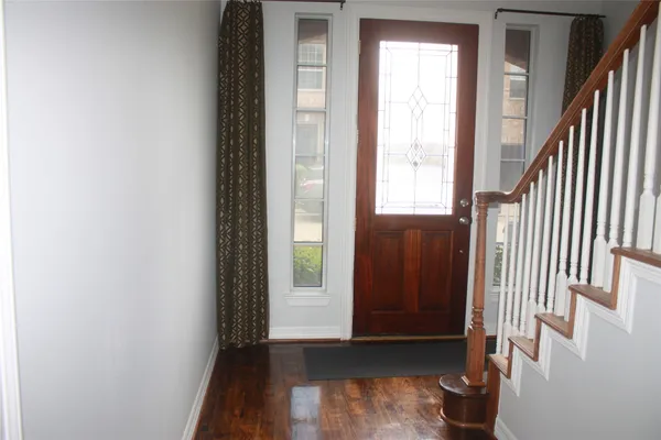 a view of an entryway with wooden floor and door