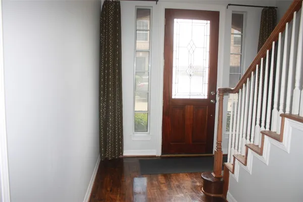 a view of an entryway with wooden floor and door