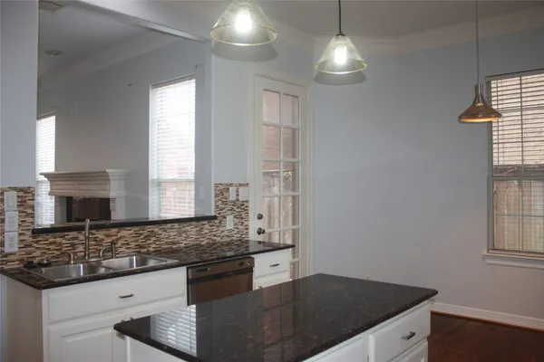 a kitchen with granite countertop a sink cabinets and window
