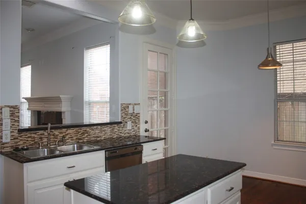 a kitchen with granite countertop a sink cabinets and window