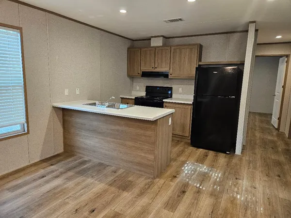 a kitchen with a sink a refrigerator and cabinets
