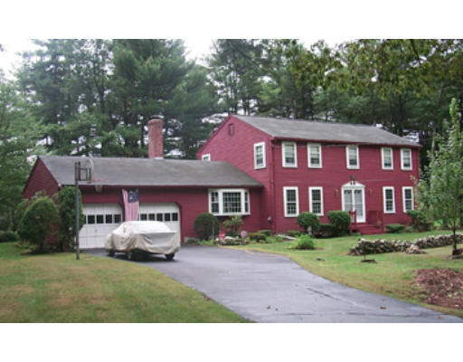 a front view of a house with a garden and trees