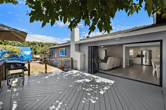 a view of a patio with table and chairs under an umbrella with wooden floor