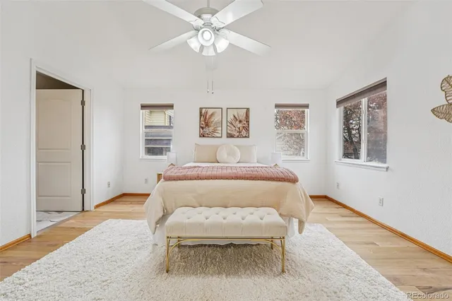a spacious bedroom with a bed and a painting on the wall