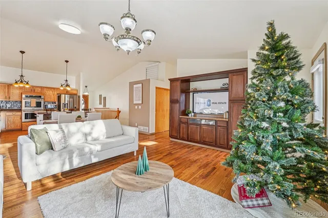 a living room with furniture kitchen view and a potted plant