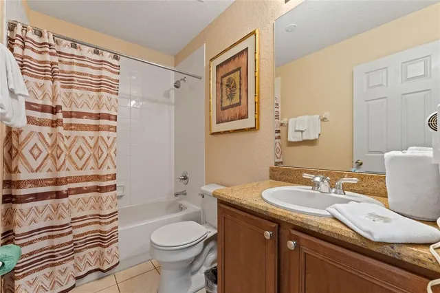 a bathroom with a sink a toilet and shower curtain