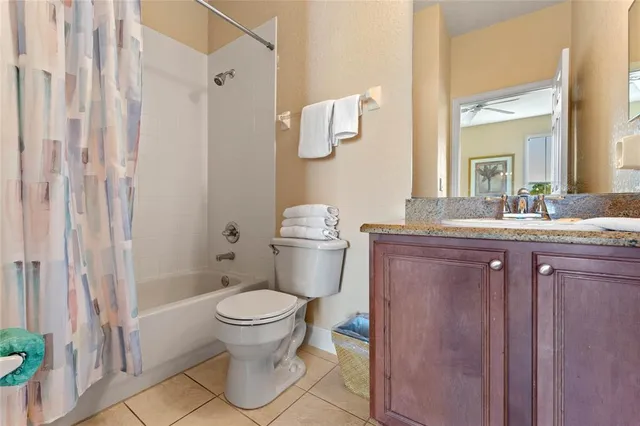 a bathroom with a granite countertop sink toilet and a mirror
