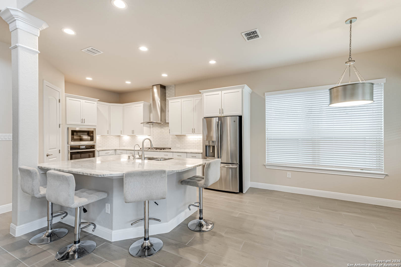 17419 Hillsedge Road San Antonio, TX 78257 - Photo 15 of 57 a kitchen with stainless steel appliances kitchen island granite countertop a stove a refrigerator and a dining table with wooden cabinet