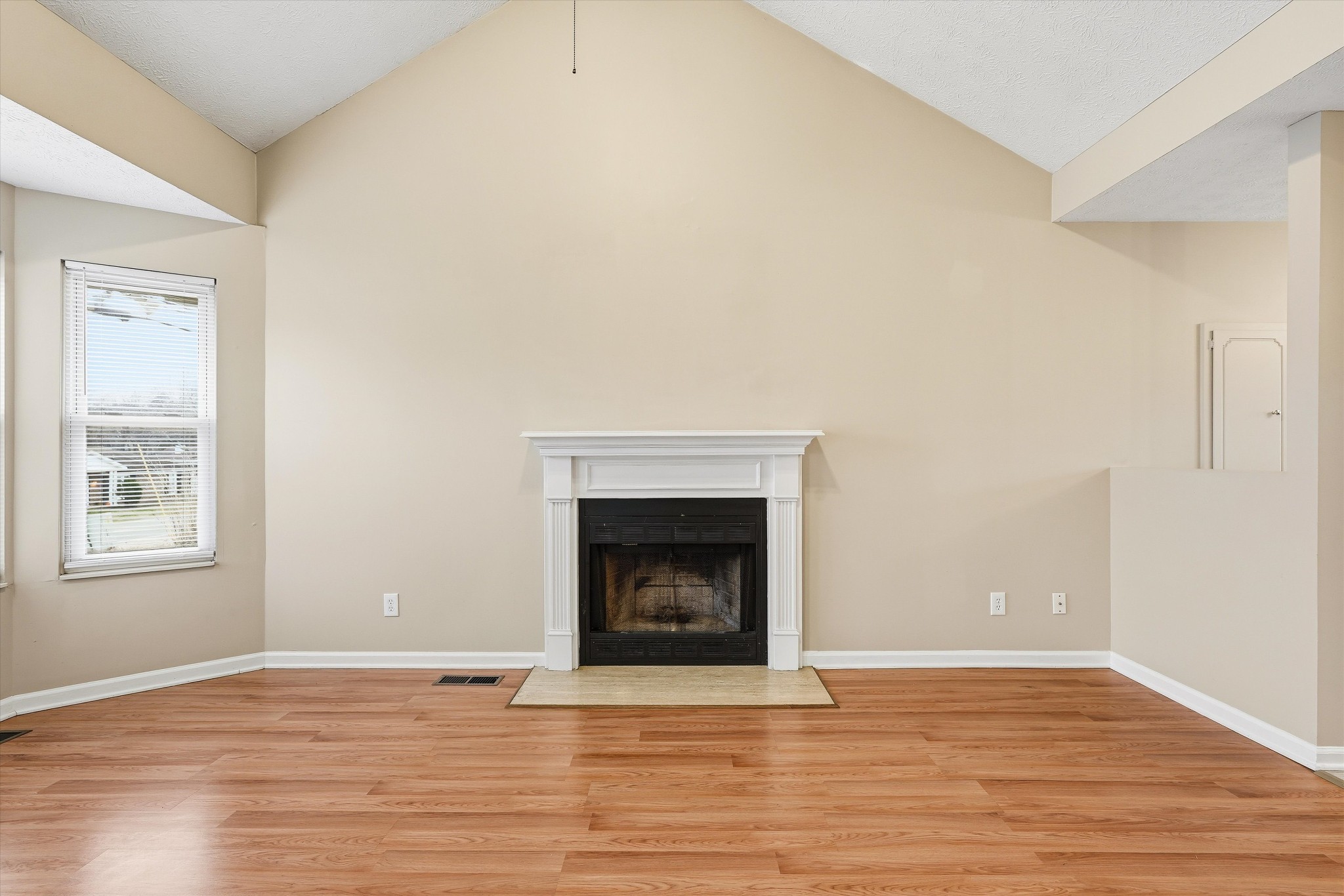 7641 Saundersville Road Mount Juliet, TN 37122 - Photo 7 of 29 a view of an empty room with wooden floor and a fireplace
