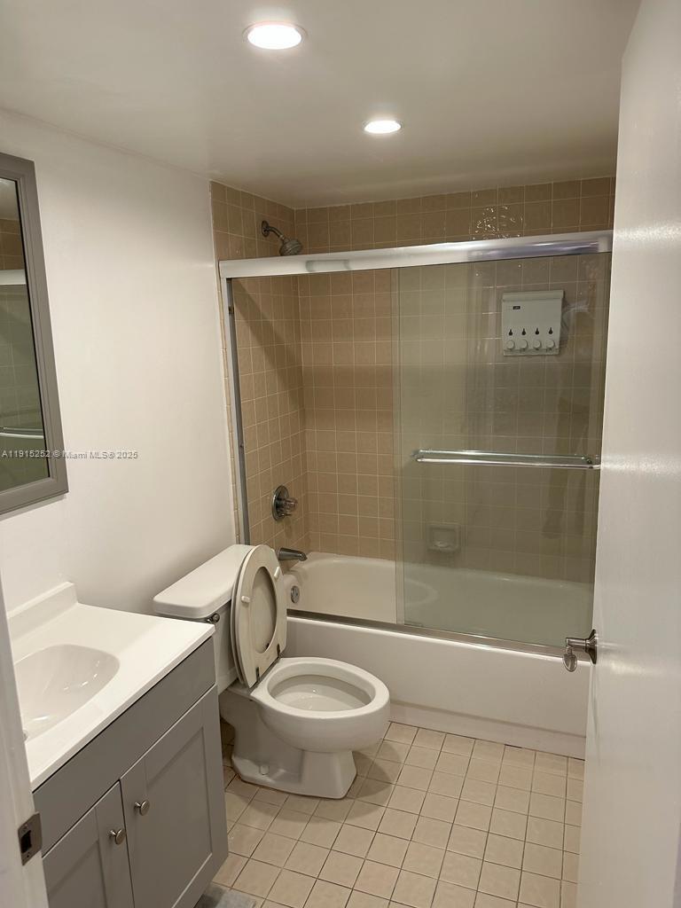 1621 Collins Avenue, Unit 505 Miami Beach, FL 33139 - Photo 13 of 25 a bathroom with a granite countertop sink toilet a mirror and shower