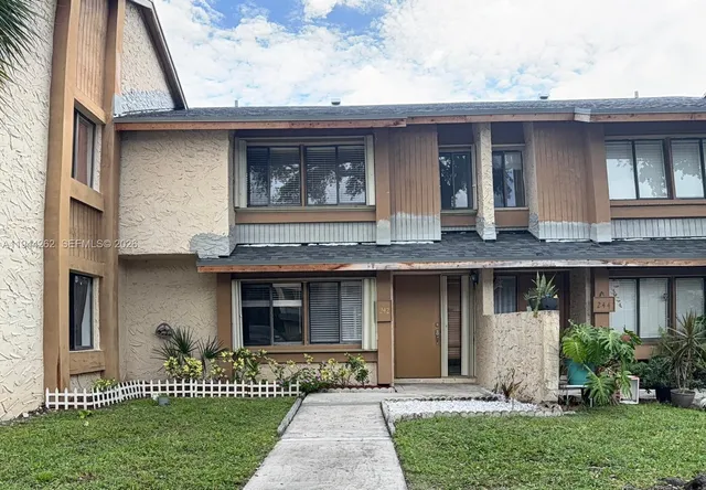 a front view of a house with a garden
